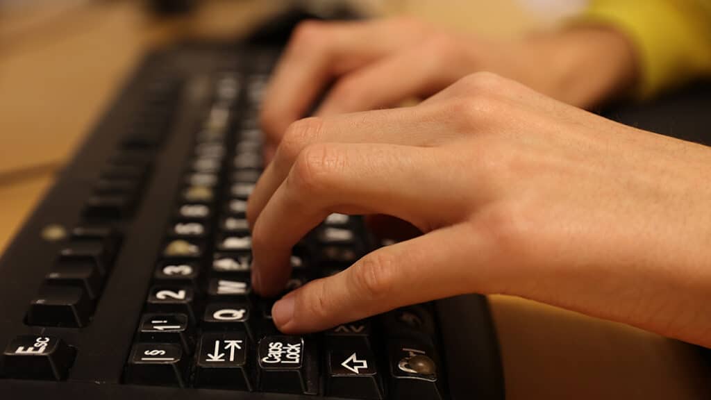 Nærbilde av Sondres hender på tastatur